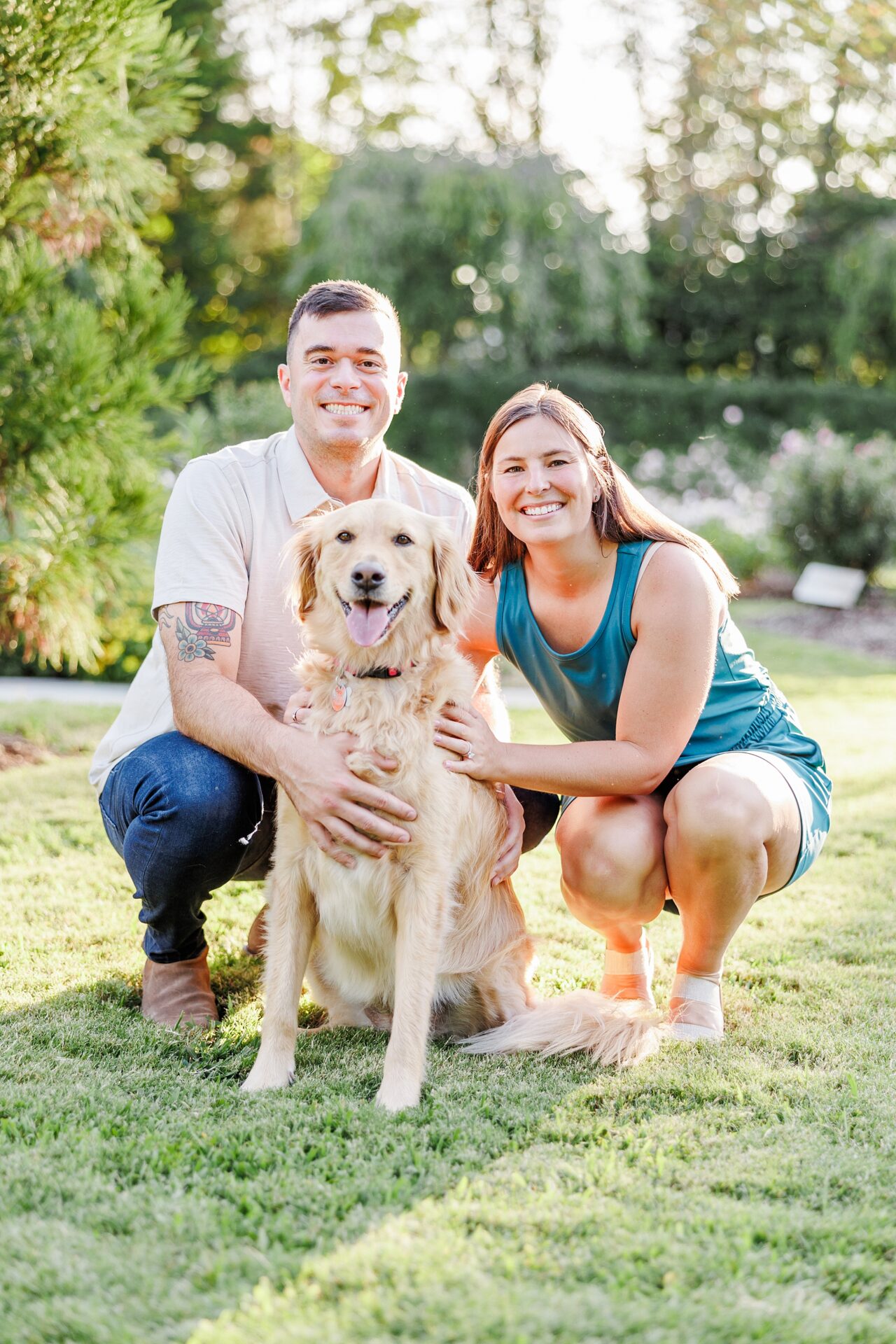 Couple poses with golden retriever during engagement photos at Reynolda Gardens